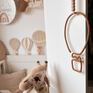 Balon ze sznurka do dekoracji wisi na szafie w pokoju dziecka.