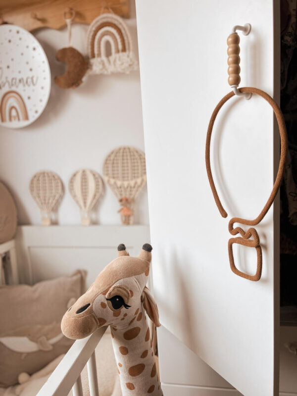 Balon ze sznurka do dekoracji wisi na szafie w pokoju dziecka.